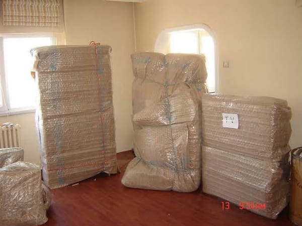 Taşımaya hazır, tek tek paketlenmiş ev eşyaları ve etiketli koliler